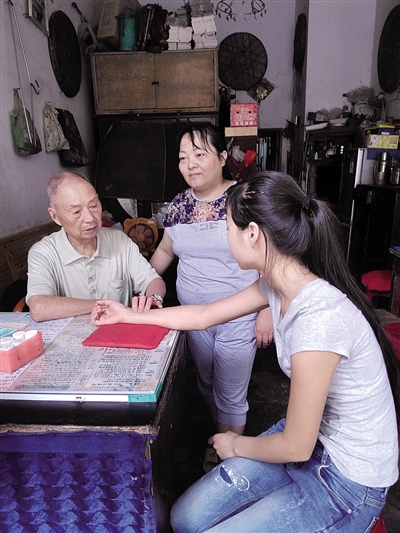 邓济良老医生在给前来看病的乡亲把脉。