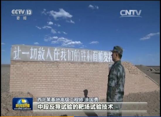 陈德明在西北某基地的标语前驻足。