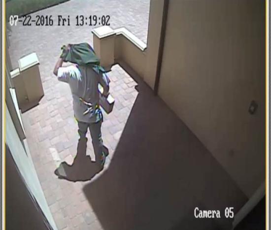 加州亚凯迪亚数个华人家庭的包裹被偷，图为在La Sierra街，一名盗贼用衣服遮住脸部偷走包裹的截图。(美国《世界日报》/张宏 摄)