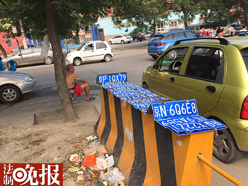 男子在摆车牌赚外快
