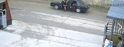 　路某被嫌犯控制在桑塔纳轿车内，嫌犯吴某下车恐吓路某，让他在车里老实一点。（视频截图）