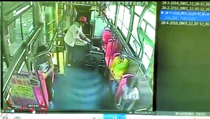 马师傅把轮椅推上公交车，并把残疾乘客安顿好。