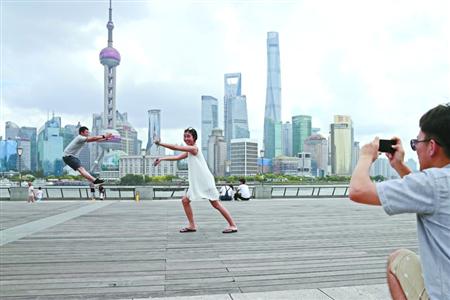 昨天的申城继续以多云为主，全市最高气温普遍在33℃、34℃附近，在外滩滨江步道上，拍照留念的游客们并没有感到炙烤感。