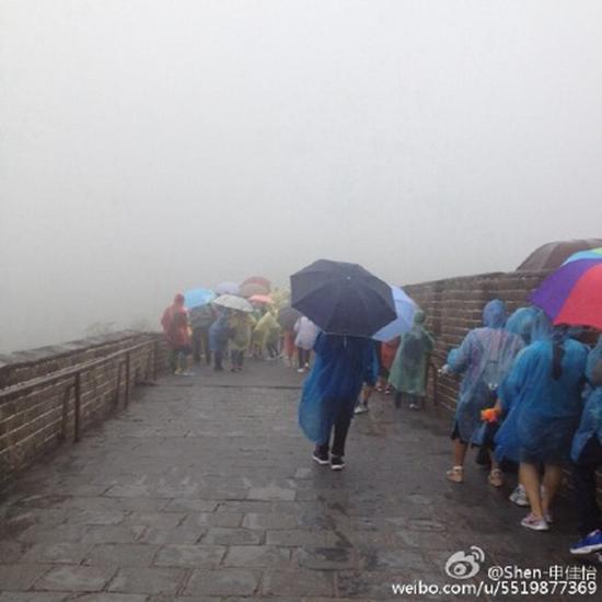 　今晨，长城降雨，路面湿滑，游客打伞行走。来源@微博网友