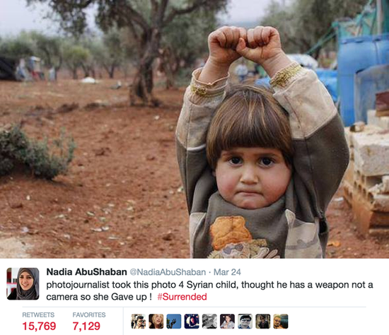 4岁的小Hudea，将长焦镜头认作武器，“举手投降”。