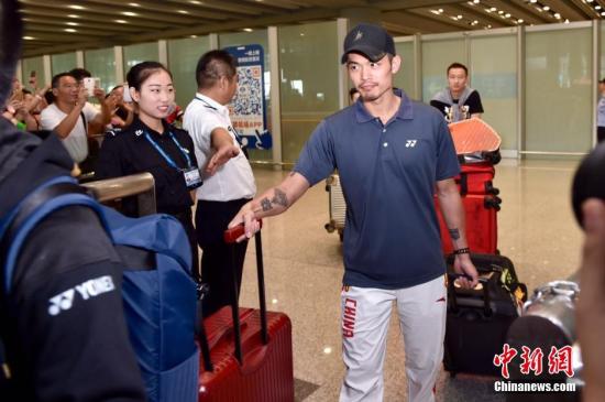 8月22日，中国奥运羽毛球队抵达首都机场，被早已等候在现场的球迷层层包围。图为林丹走出机场，受到好友鲍春来的热情迎接。中新网记者 金硕 摄