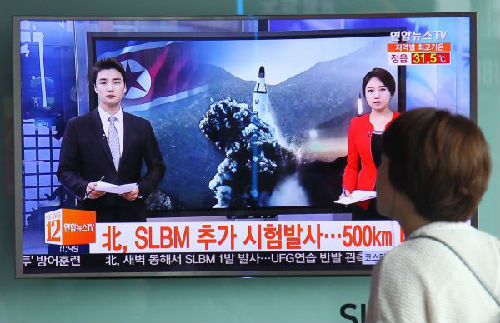 2016年8月24日，在韩国首尔火车站，旅客通过大屏幕观看关于朝鲜发射导弹的电视节目。 新华社发