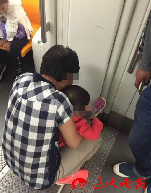 　在地铁车厢里，老人给孩子把尿。 读者供图
