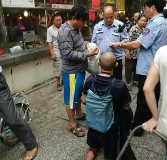 广州黄浦区某菜市场，报警后，当地警方来到现场调查情况，左侧穿横条衣服男子疑似为彭小六的控制者。