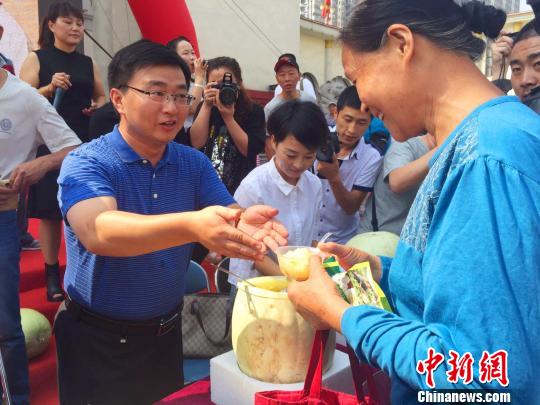 万荣县县长李永辉为市民送上免费品尝的三白瓜。　任丽娜 摄