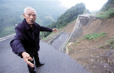 昨日，64岁的饶叔讲述省道塌方前自己冒雨拦车时的情况。本报记者 雷键 摄
