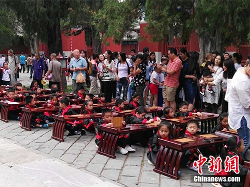 9月1日，有小学在北京孔庙举行入学“开笔礼”仪式，小学生穿着汉服，周围还有家长。中新网记者 宋宇晟 摄
