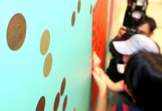 蔡英文办公室开放参观首日，陆客在贴板上写“九二共识”表祝福。（图片来源：台湾《联合报》）