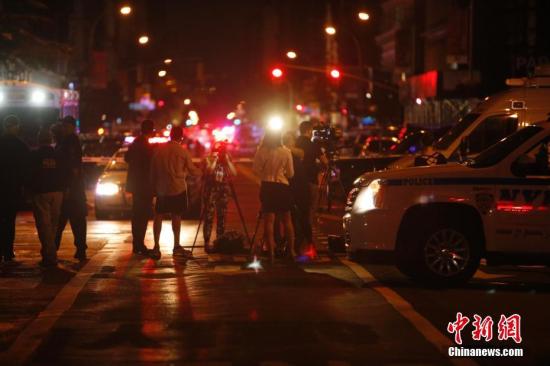 当地时间9月17日，纽约曼哈顿切尔西街区，记者在警戒区外采访。当晚，纽约曼哈顿切尔西街区的爆炸已造成29人受伤，一人伤势较重，但无生命危险。初步调查显示，这是一起“蓄意行为”，但目前尚无证据显示爆炸与恐怖袭击有关。中新社记者 廖攀 摄