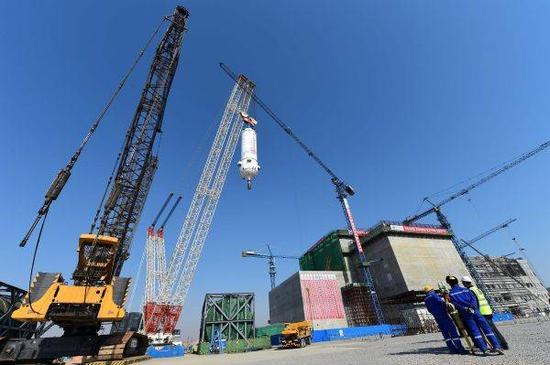 资料图片：3月20日，在华能山东石岛湾核电厂，反应堆压力容器在吊装中。新华社记者 郭绪雷摄