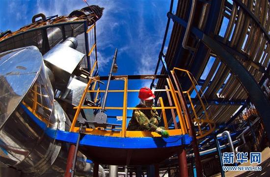 国有企业改革在各地推进。新中国第一家化工企业——吉林石化公司2014年减亏增效11.9亿元，这是工人在维护该公司新建千万吨炼油基地（2015年9月18日摄）。