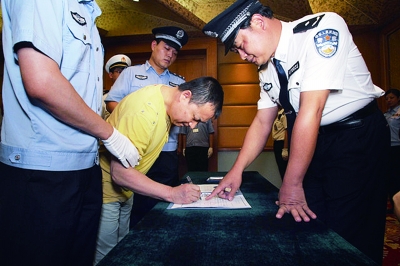 ▲犯罪嫌疑人黄海勇在逮捕证上签字