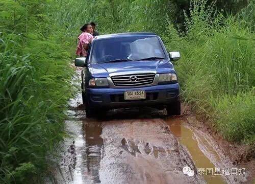 大妈在路上的泥水潭里面搓澡。