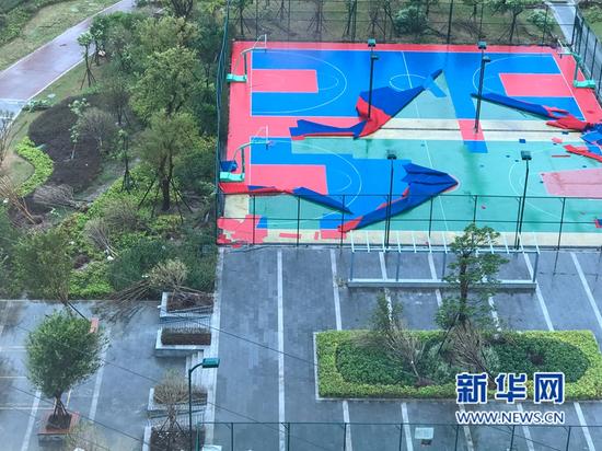 福州晋安区光明港公园操篮球场地面被大风撕裂。（图/新华网）