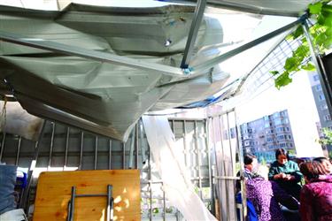 昨日下午，在沈阳市洪汇路8-3号居民楼附近，一处彩钢房扭曲变形，跳楼男子摔在彩钢房并将其砸穿，地砖碎裂并凹陷。辽沈晚报、聊沈客户端记者　白琳　摄