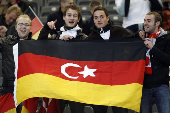 在德土耳其人手持德国-土耳其国旗混合的旗帜