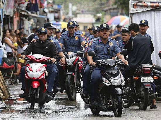 10月6日，参与“缉毒战争”行动的菲律宾警方人员骑着摩托车，在马尼拉一贫民区进行巡逻。