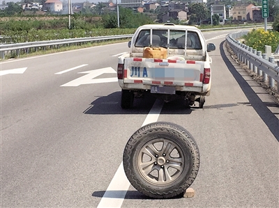 跑脱的轮胎被当成警示牌放在车后。