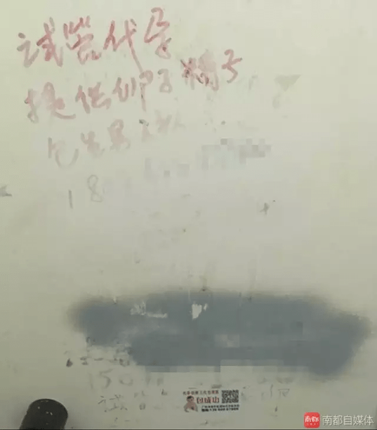 广州某三甲医院生殖中心的厕所里，贴着写着代孕的小广告。南都记者 摄