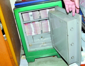 警方在东莞破获一宗地下钱庄案时，从一个保险箱中缴获满满一箱涉案现金。