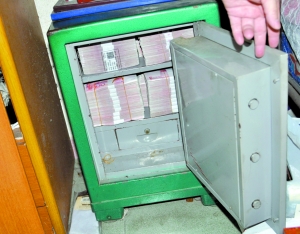 警方在东莞破获一宗地下钱庄案时，从一个保险箱中缴获满满一箱涉案现金。