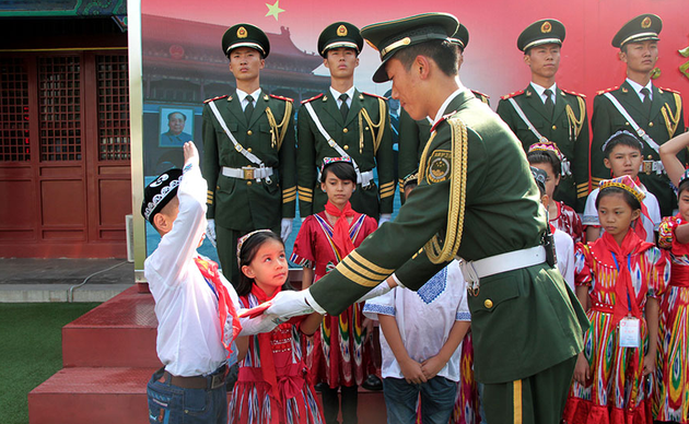 2014年09月24日,北京,国旗护卫队员向维族少年赠送国旗。
