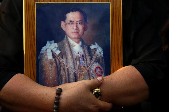 泰国民众怀抱着普密蓬国王的肖像