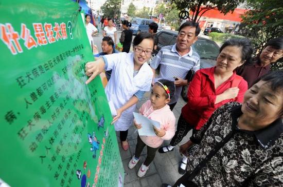 资料图片：工作人员在街头向居民讲解狂犬病防治知识。 新华社记者杜宇摄