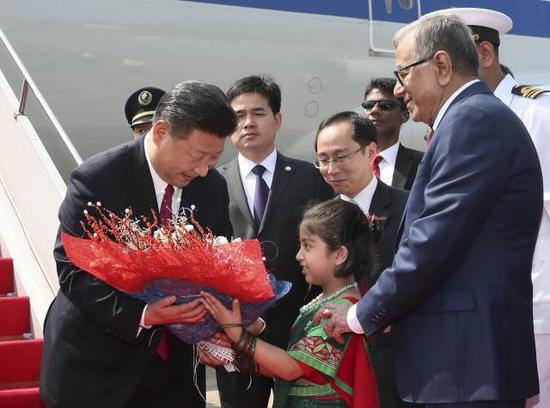 图为10月14日，国家主席习近平抵达达卡，开始对孟加拉人民共和国进行国事访问。这是习近平接受孟加拉国儿童献花。（新华社记者兰红光摄）