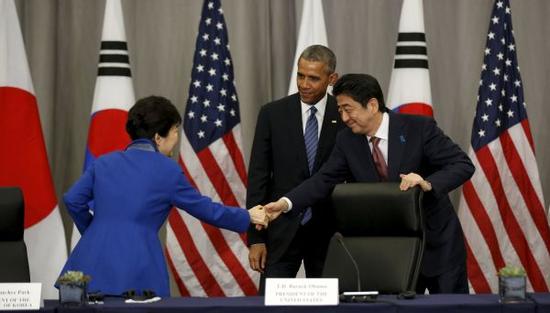 2016年3月31日,在美国首都华盛顿,韩国总统朴槿惠(左)和日本首相安倍晋三(右)在美国总统奥巴马(中)的注视下握手(资料图)