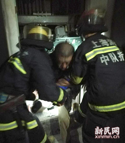 图说:消防队员将被困轿厢的人员从约半米的缝隙中拖出。虹口消防 图