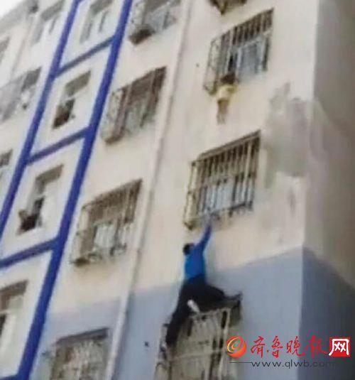 梁磊从楼外徒手爬上三楼，站在防盗窗上托举孩子十几分钟。（视频截图）