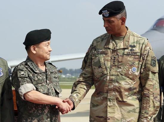 9月13日,韩国乌山空军基地,驻韩美军司令布鲁克斯(右)与韩国联合参谋本部议长李淳镇在美军B-1B战略轰炸机抵达仪式上握手。(新华/美联)