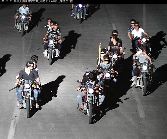 警方提供的监控视频截图显示，2015年4月30日夜，广东揭阳，一群90后骑着摩托车在公路上上演“速度与激情”，手持砍刀、九环刀等无端殴打砍伤路人。视觉中国供图（资料照片）