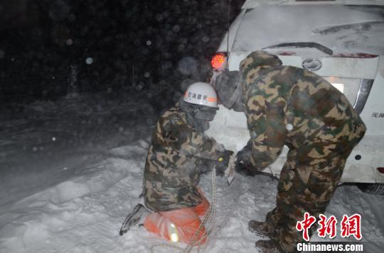 图为消防救援人员给被困车辆安装救援绳。 李江江 摄
