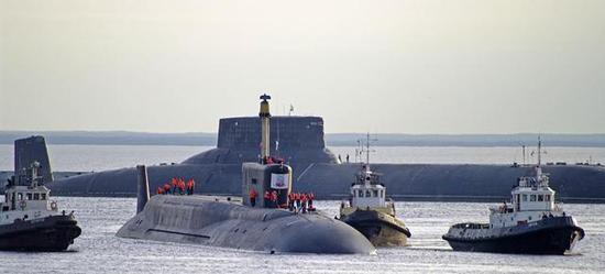 资料图：俄军新老两代核潜艇合影，现役的北风之神级核潜艇遇上巨大的台风级显得十分娇小
