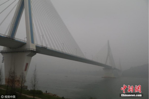 受华北霾团输入及宜昌市地理、气象条件影响,湖北宜昌出现严重雾霾天气,夷陵长江大桥笼罩在雾霾中。