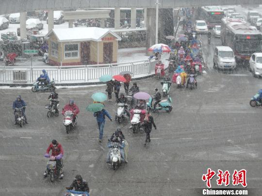 图为郑州街头，行人在大雪中艰难行进。 韩章云 摄