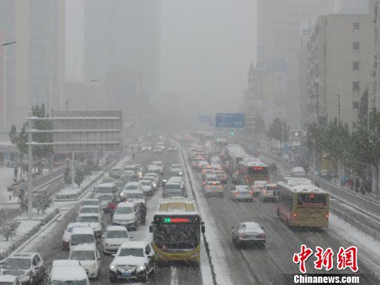 图为郑州主干道，大雪中车辆通行缓慢。 韩章云 摄
