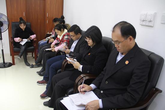 图为法官们认真做学习笔记。