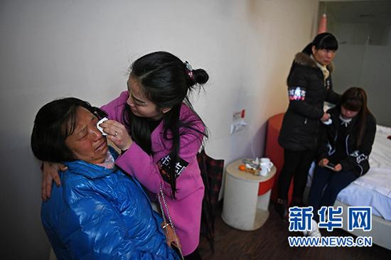 11月26日，心理疏导志愿者在事故现场附近的宾馆抚慰来自湖北的遇难者家属。新华社记者 万象 摄