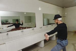 王世金在卫生间水房对着镜子揣摩舞蹈动作