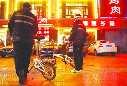 两位代驾司机守候在寒风中,等待出店的顾客是否需要代驾。 /CFP