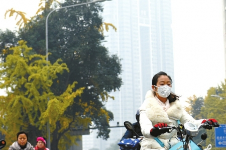 成都持续雾霾天气，市民戴着口罩出行。 刘陈平 摄