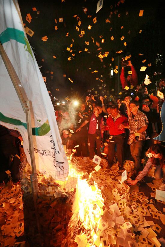 劳工团体洒冥纸、焚烧冥纸，摆上“灵位”与蔡英文竞选时的点亮台湾的旗子，高喊“缩减工时，过桥喔”！（图片取自台湾《联合报》）
